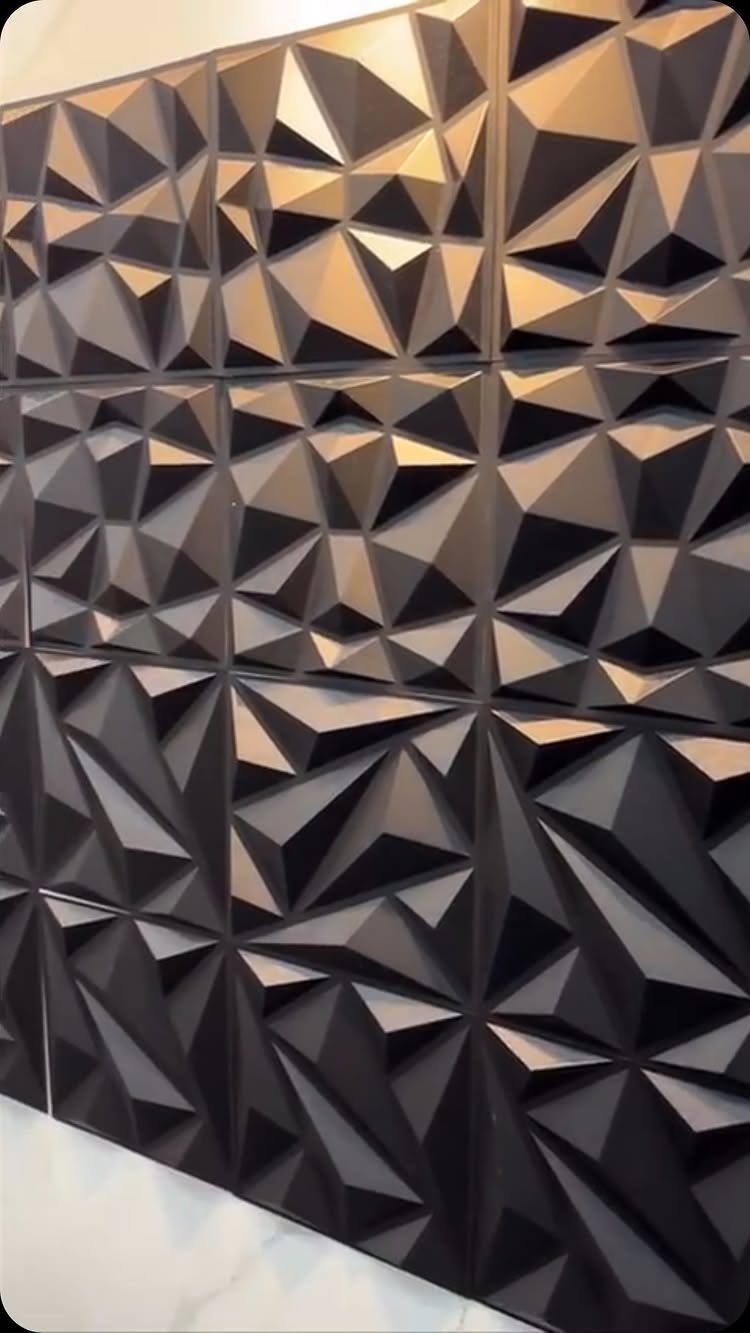 20 Bedroom Wall Designs for Accent, Texture and Art 3 Black geometric 3D wall tiles with faceted surfaces creating dramatic light and shadow effects.