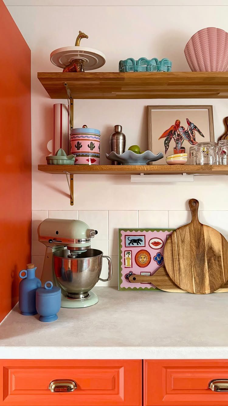 15 Kitchen Renovation Ideas for Getting the Function Back Into the Room 1 Two wooden floating shelves holding colorful ceramics and glassware against a white wall.