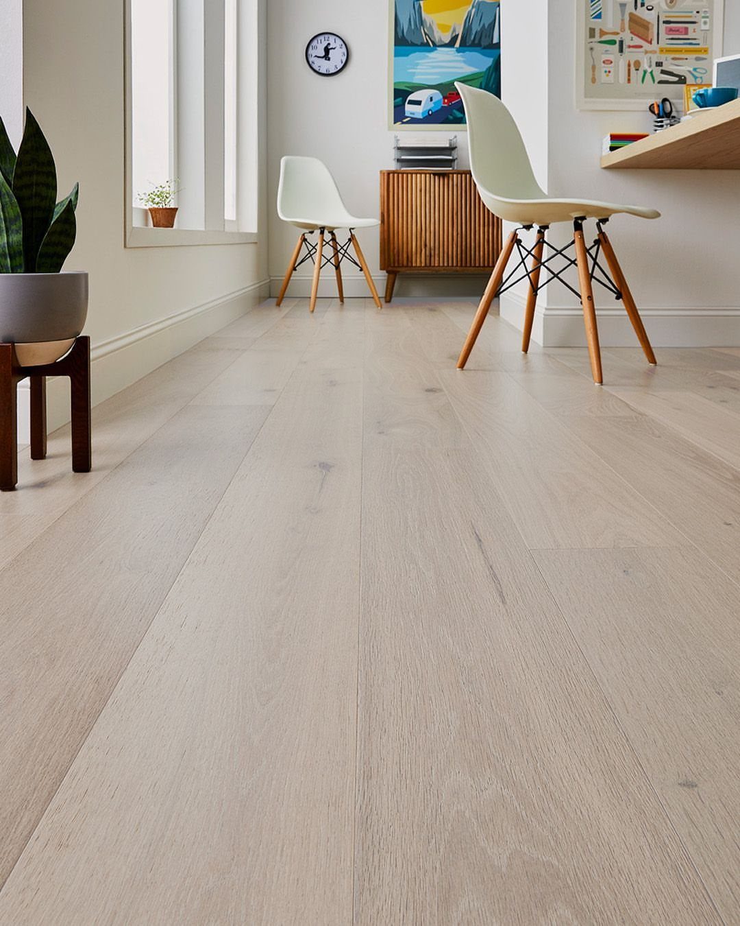 Light blonde wide plank wood flooring in a bright mid-century modern styled room.
