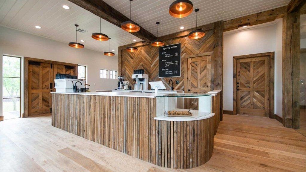Dark wood planks arranged in a chevron pattern on a cafe wall behind a wooden counter.