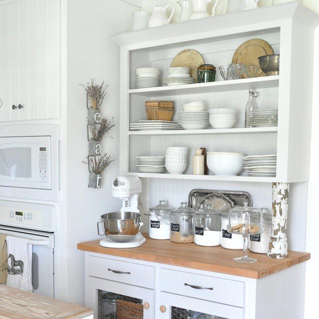 15 Kitchen Renovation Ideas for Getting the Function Back Into the Room 9 White wooden baker's table with light wood top holding a stand mixer and various kitchen dishes.