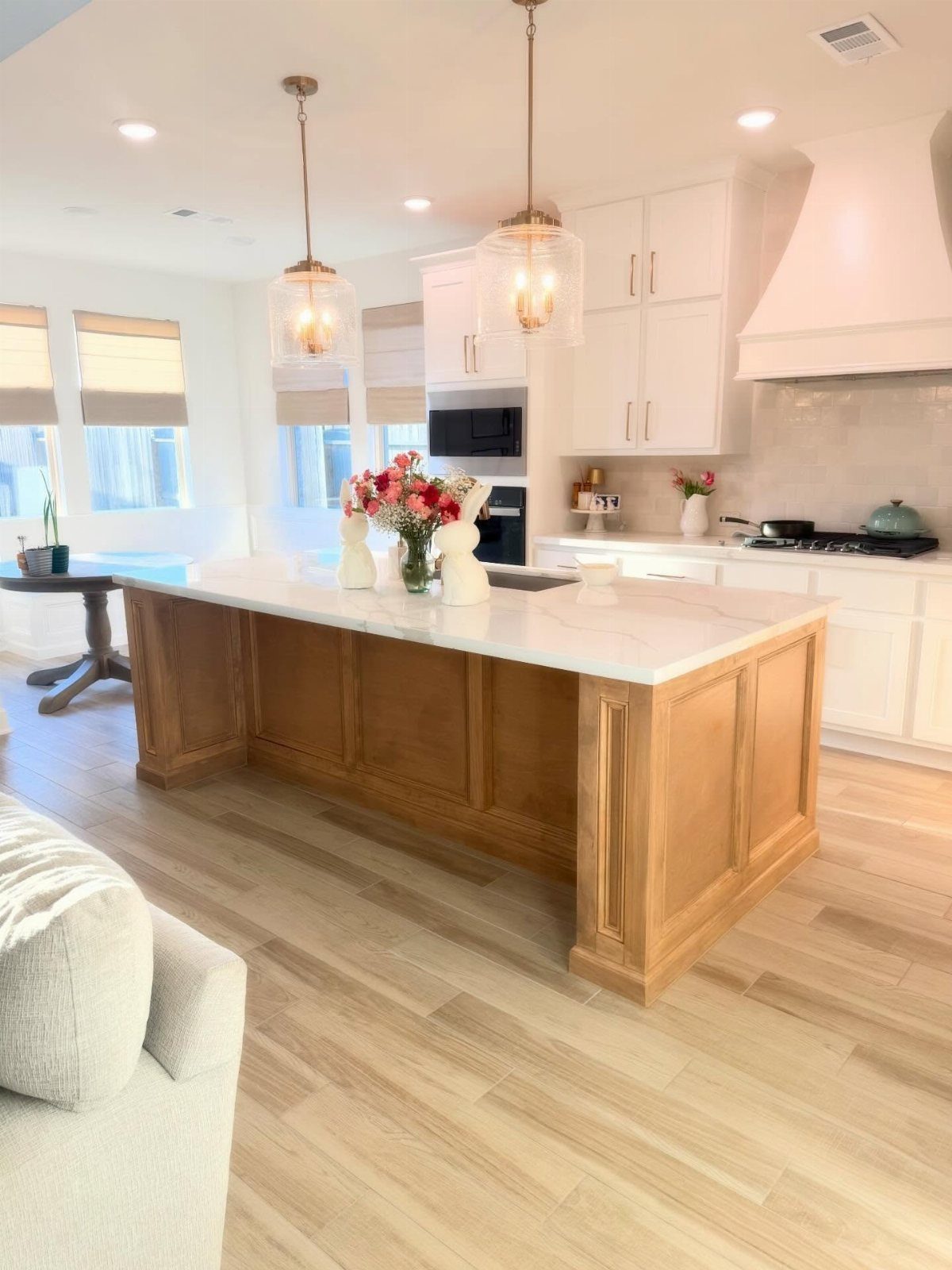 15 Kitchen Renovation Ideas for Getting the Function Back Into the Room 6 A large wooden kitchen island with a white marble countertop in a bright, modern kitchen.