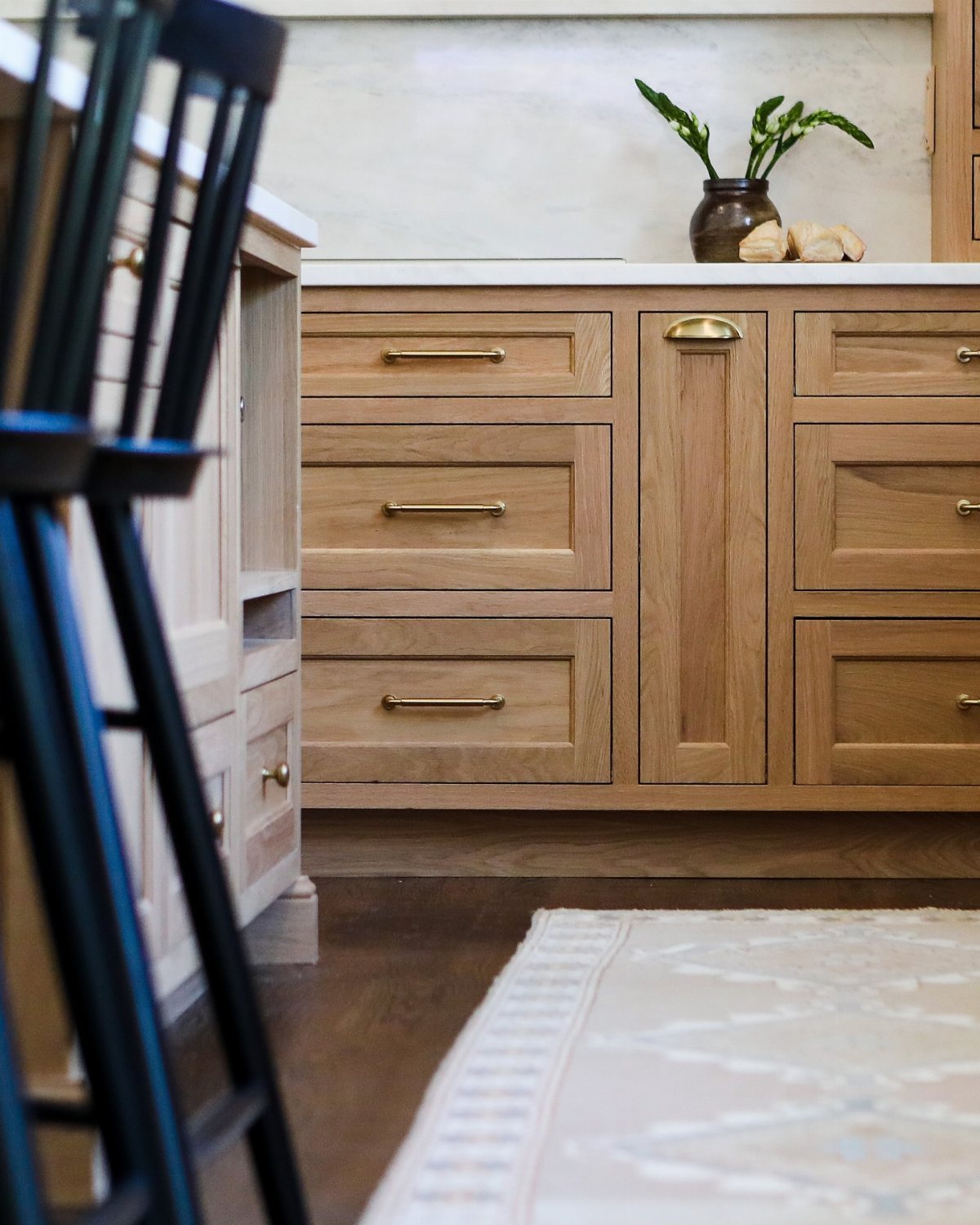 Dark Wood Floors Kitchen: 6 Looks That Balance the Floor 5 Light wood kitchen cabinets and dark wood floors with a patterned rug.