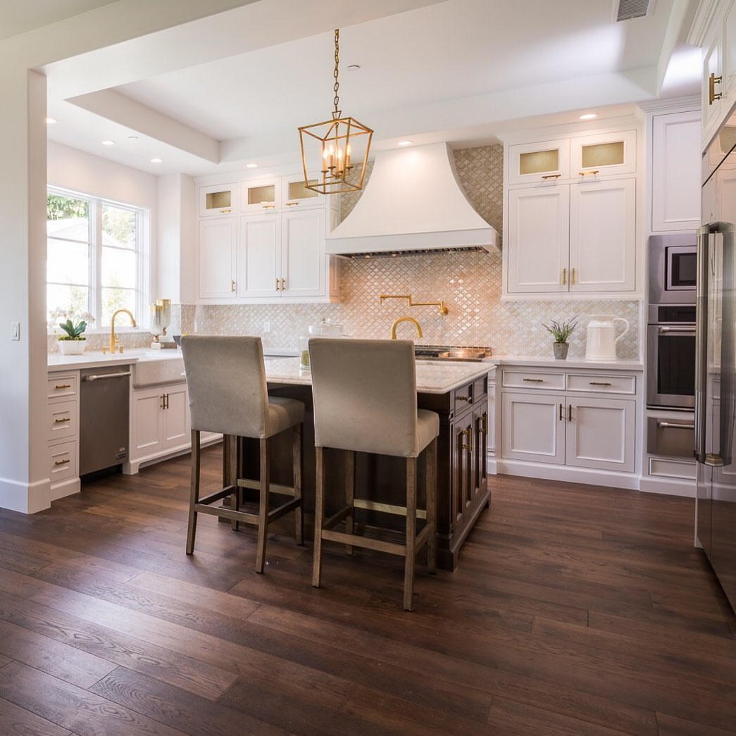 Modern kitchen with white cabinets, a dark wood island, and dark wood plank flooring.