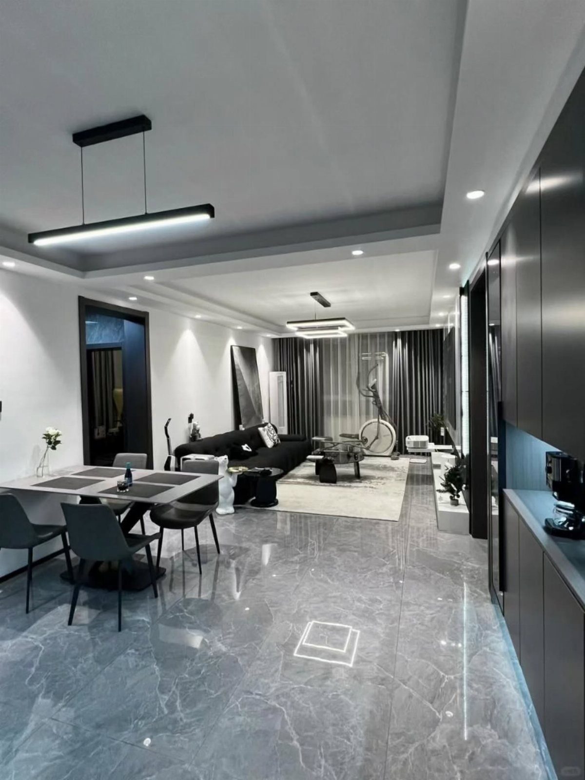 Polished gray marble-effect flooring in a modern living and dining room interior.