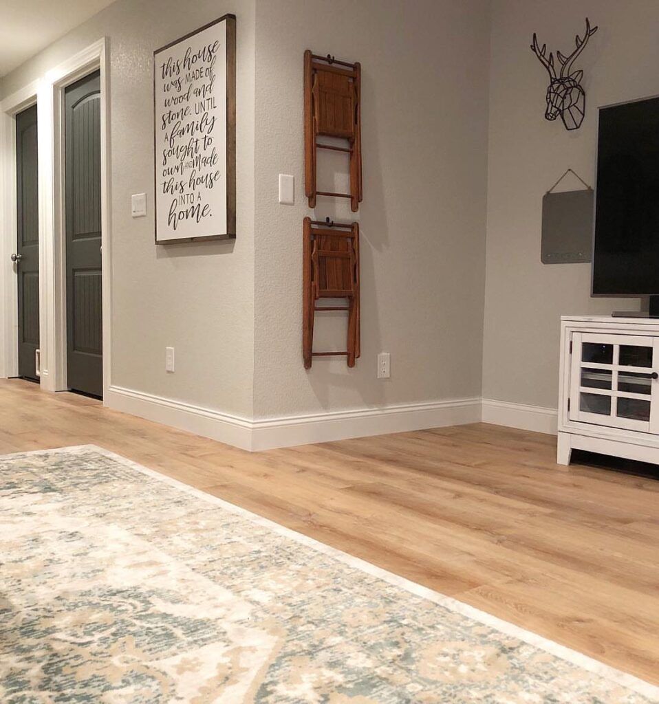 Light oak colored luxury vinyl flooring in a living room with a patterned rug.