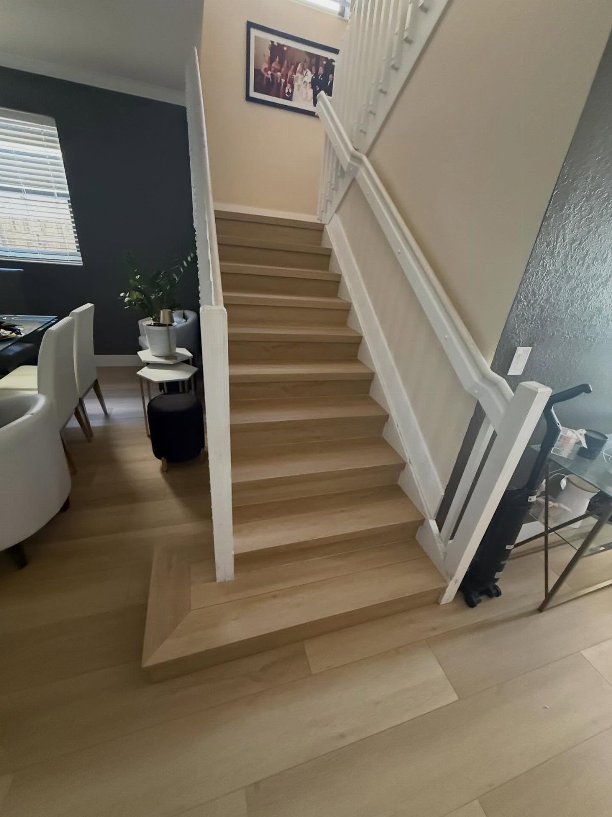 Light wood-look flooring covering the floor and stairs in a modern home interior.