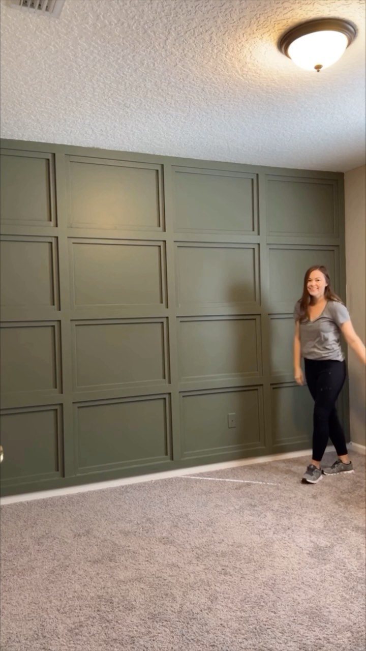 Molding Boxes on Wall: 6 Styles From Grid Panels to Botanical Frames 3 A woman walking in front of a sage green wall with grid pattern molding boxes.