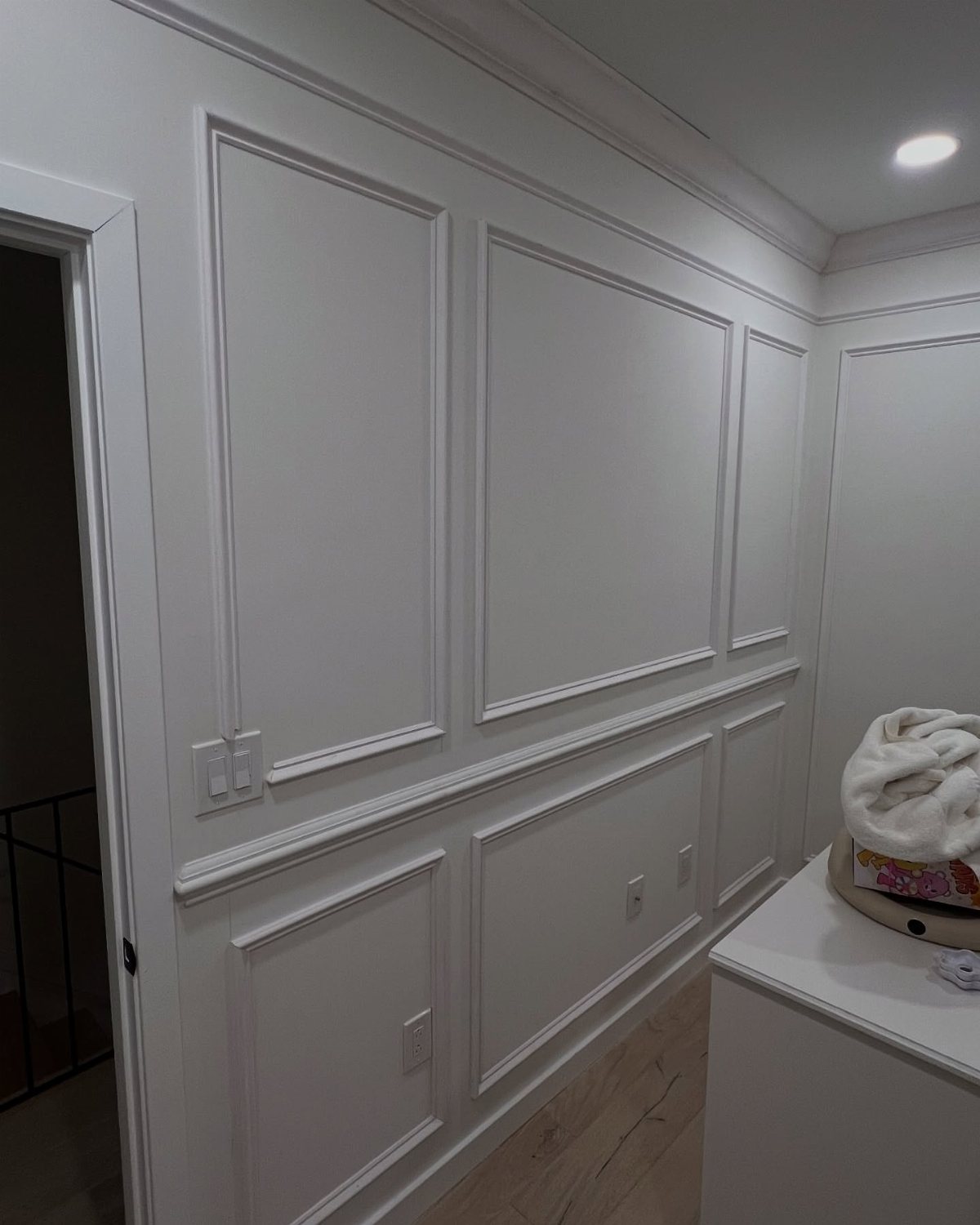 Molding Boxes on Wall: 6 Styles From Grid Panels to Botanical Frames 2 White wall decorated with rectangular picture frame molding and wainscoting panels.
