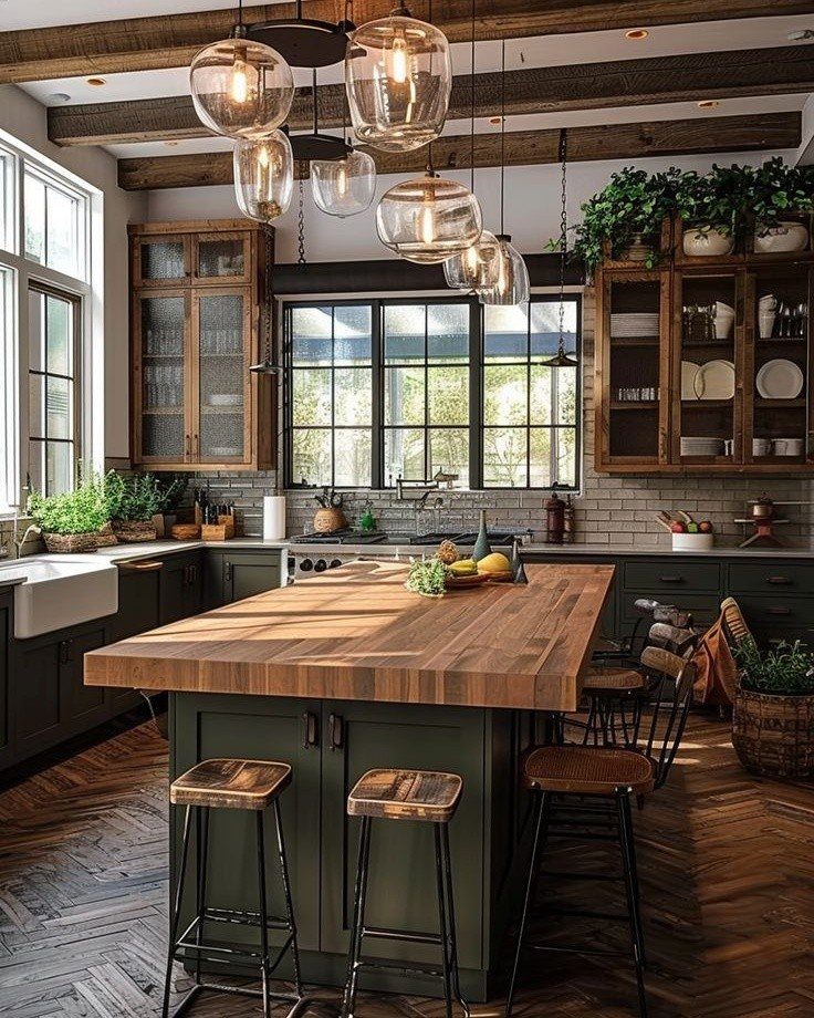 A kitchen island with a thick wood butcher block countertop and dark green base with stools.
