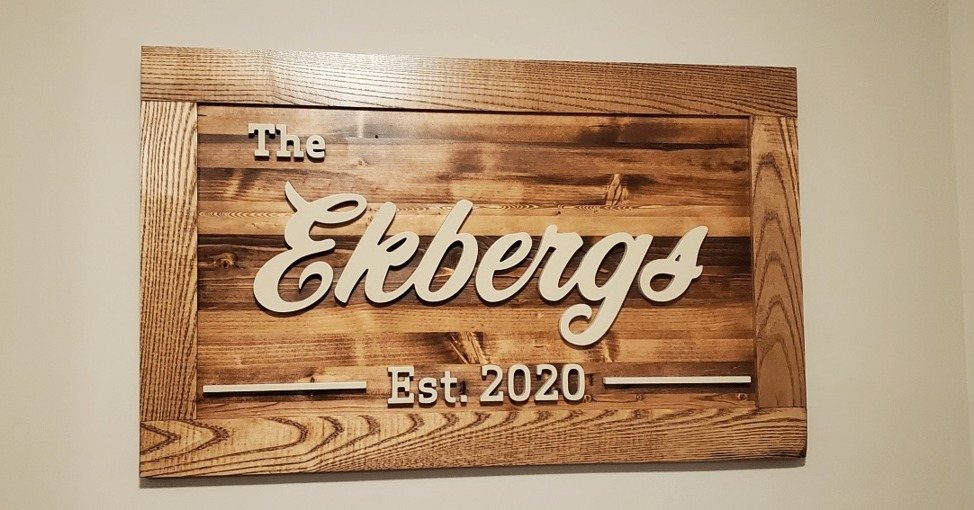 A rustic wooden sign displaying the family name Ekbergs and established date 2020.