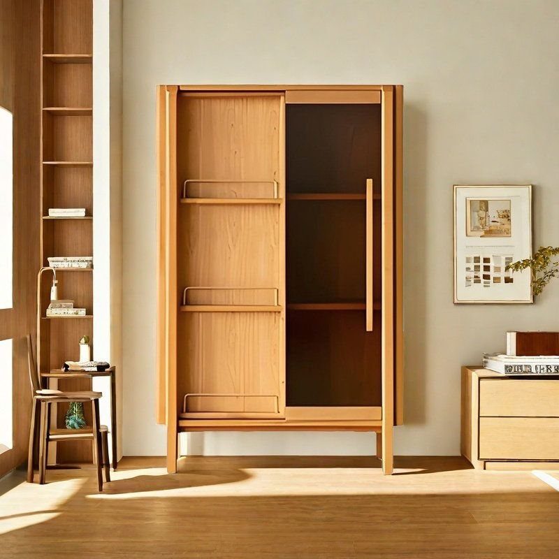 A light wood sliding door bookcase with open shelves against a beige wall.