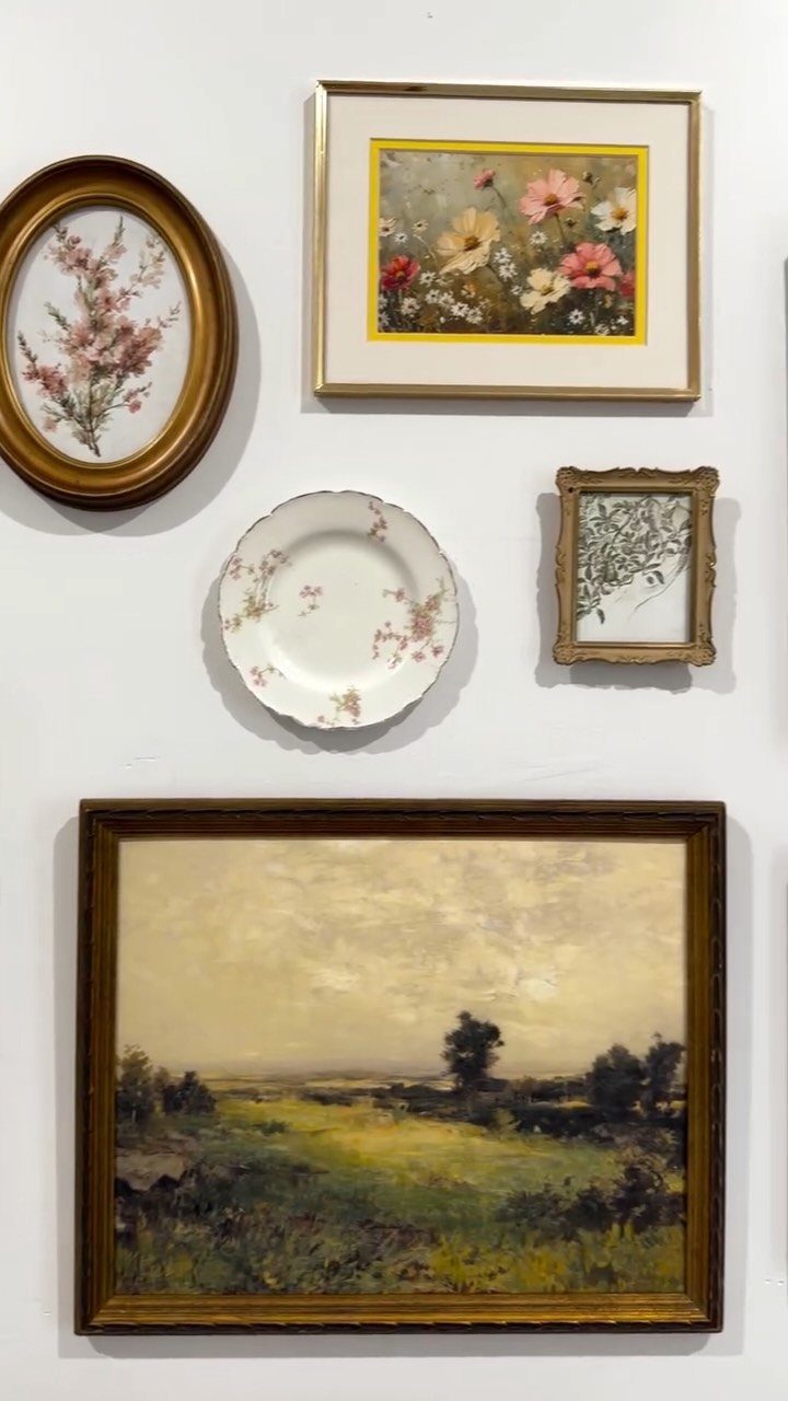 21 Bedroom Wall Decor Ideas With Photos for Every Style 16 Various framed artworks and a decorative plate arranged on a white wall.
