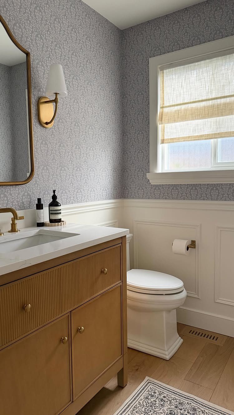 White wainscoting paired with grey patterned wallpaper in a bright, modern bathroom setting.