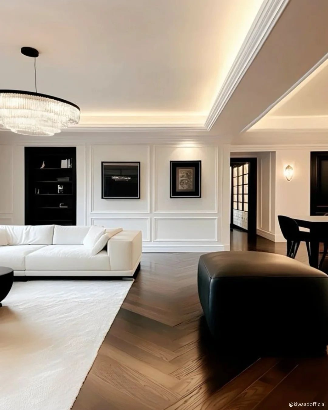 Modern living room with white furniture and dark wood chevron patterned flooring.