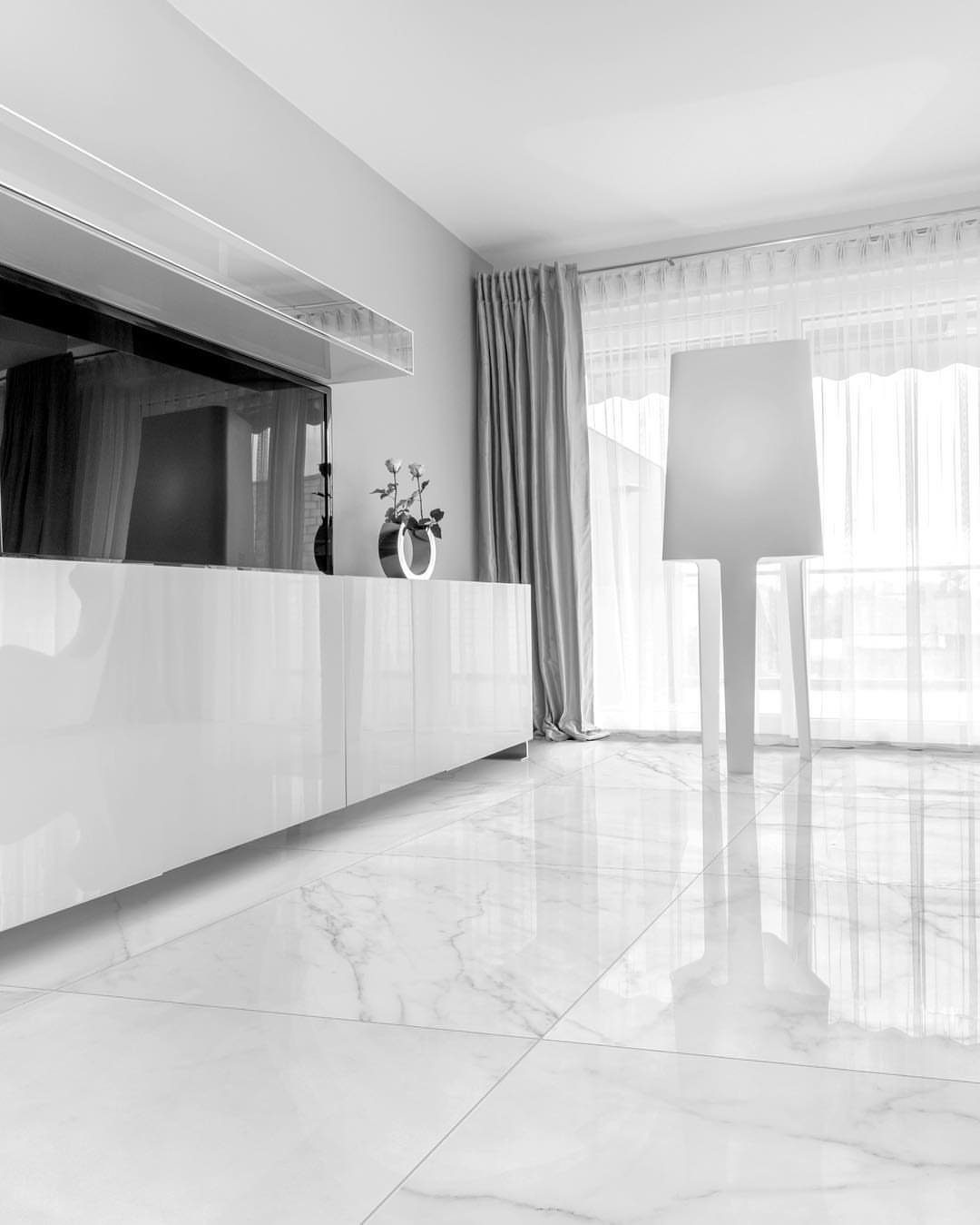 White marble tiles with gray veining in a bright, modern living room setting.