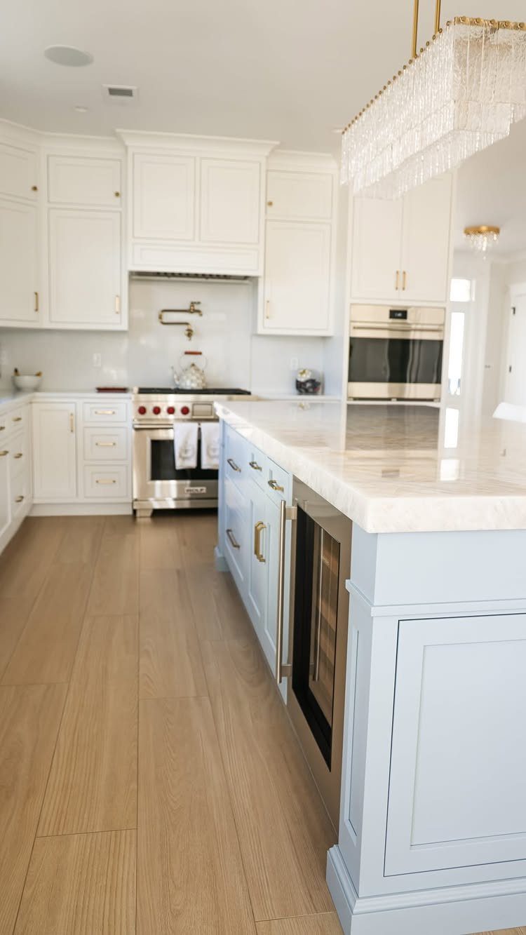 Kitchen Floor Tiles Design: 13 Ideas for Stone, Ceramic & Patterned Floors 4 Light wood-look tile flooring in a bright kitchen with blue cabinets and marble countertops.