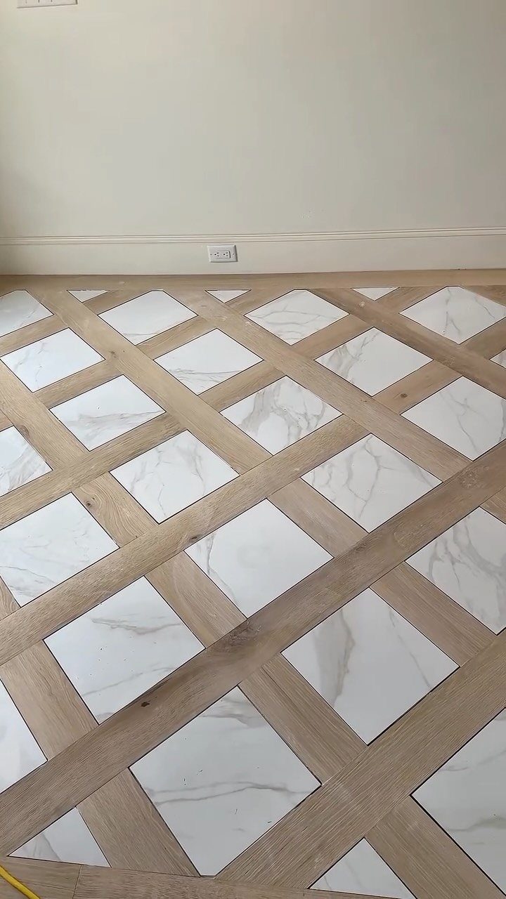 Light wood planks and white marble tiles arranged in a diamond grid pattern on a floor.